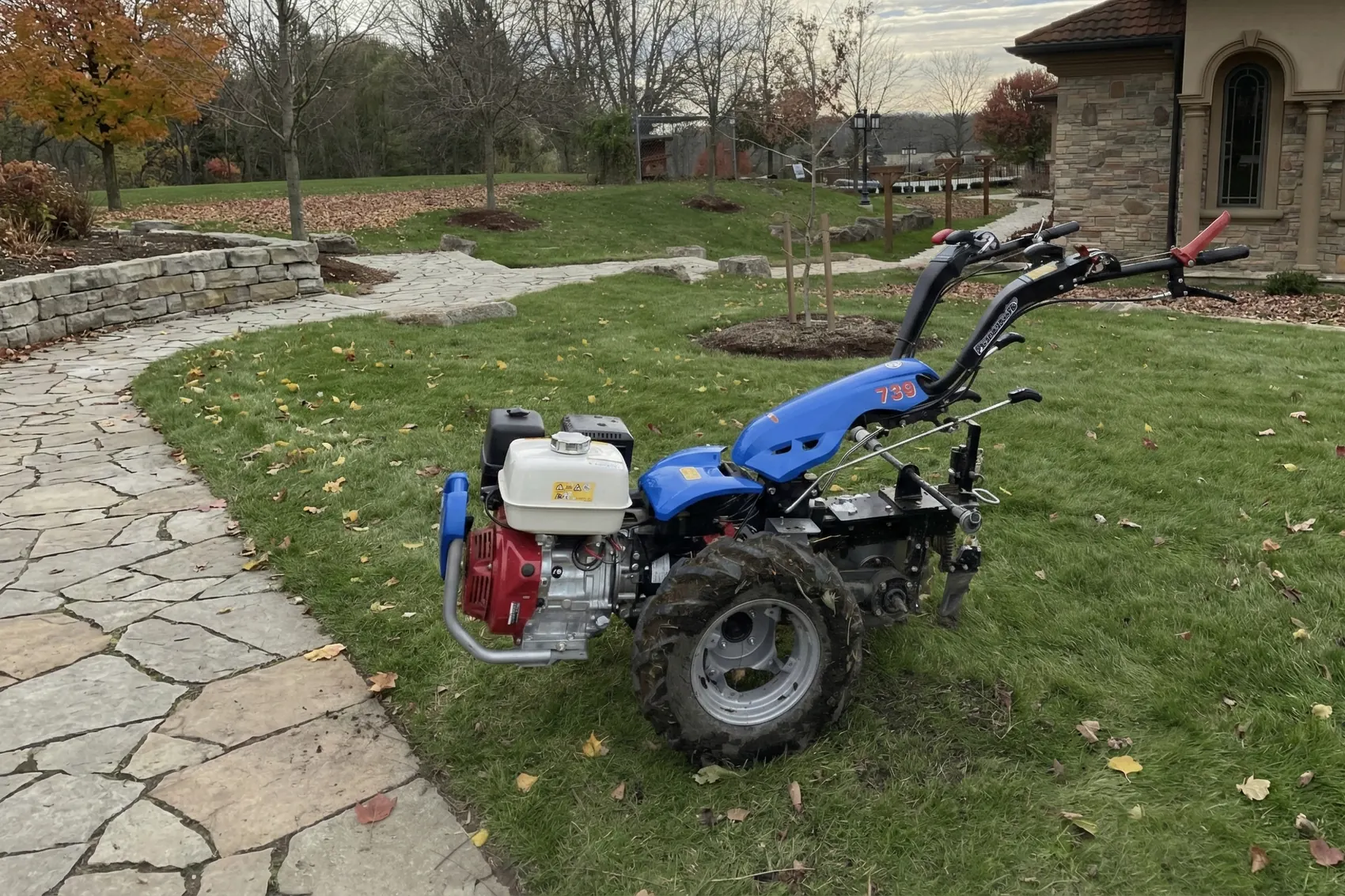 The walk-behind trencher on a front lawn beside a flagstone path